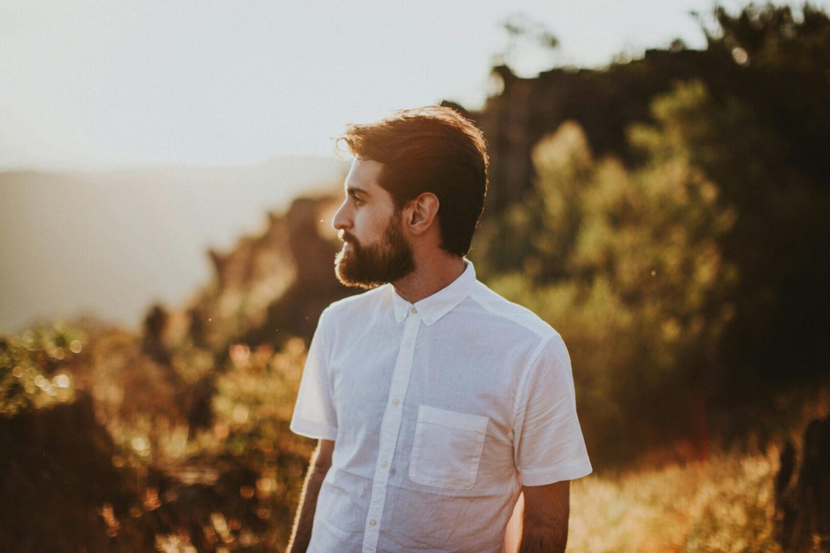 Man with beard looks to the side.