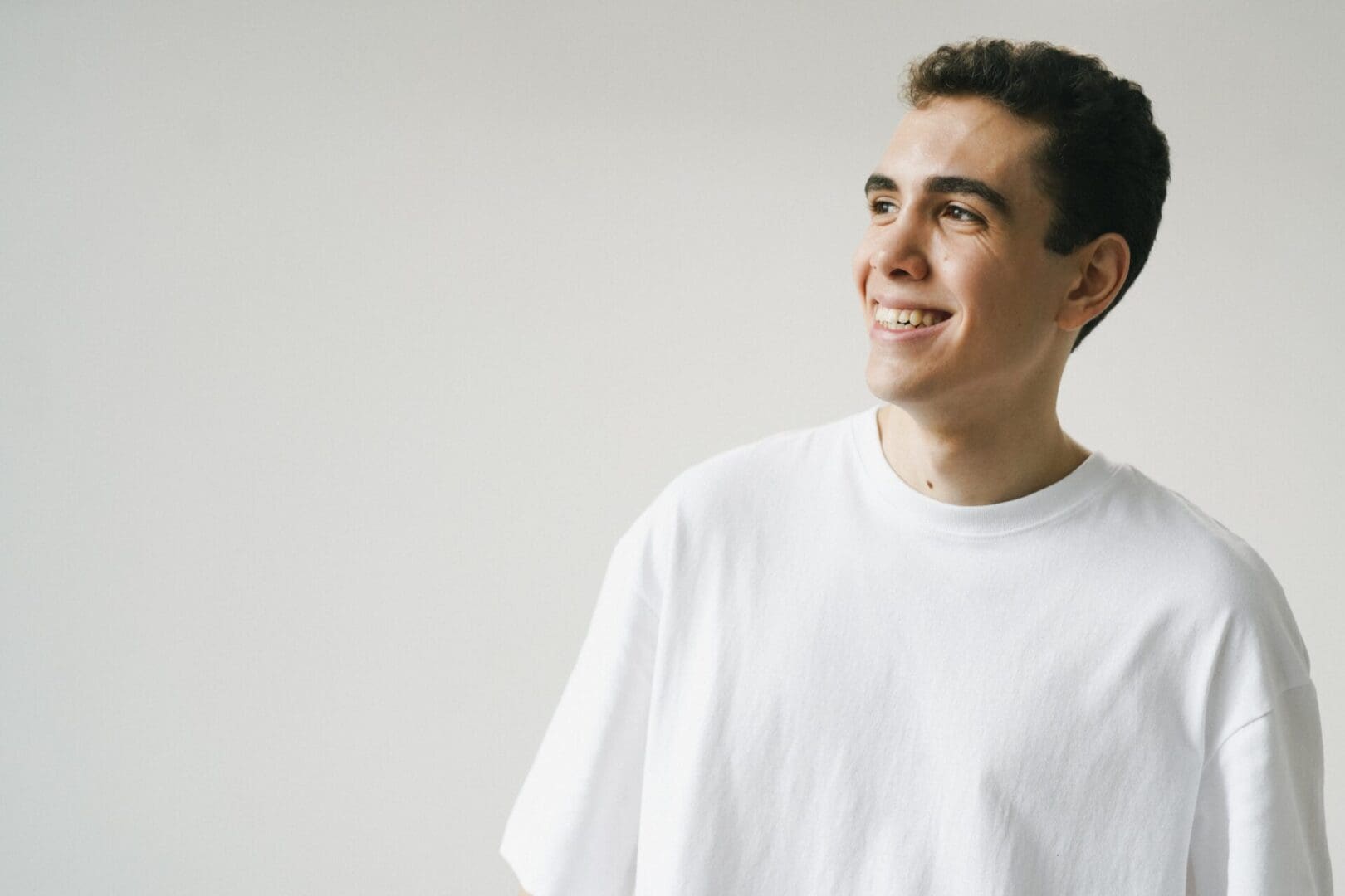 Smiling man in a white t-shirt.